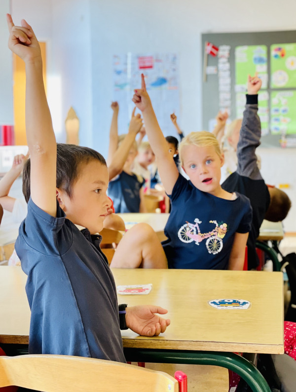 En skov af hænder i vejret fra elever i et klasselokale hos privatskolen i Sæby